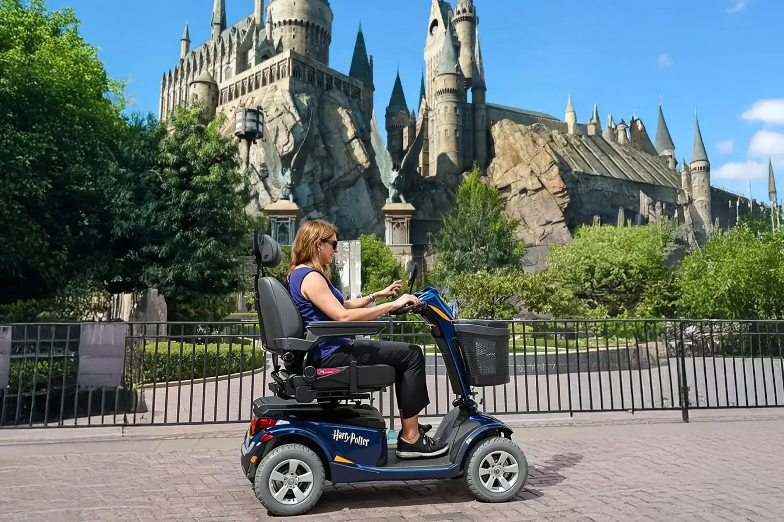 Un visitante de Universal Studios Orlando explorando el Mundo Mágico de Harry Potter con la comodidad de un scooter de movilidad alquilado en Cloud of Goods.