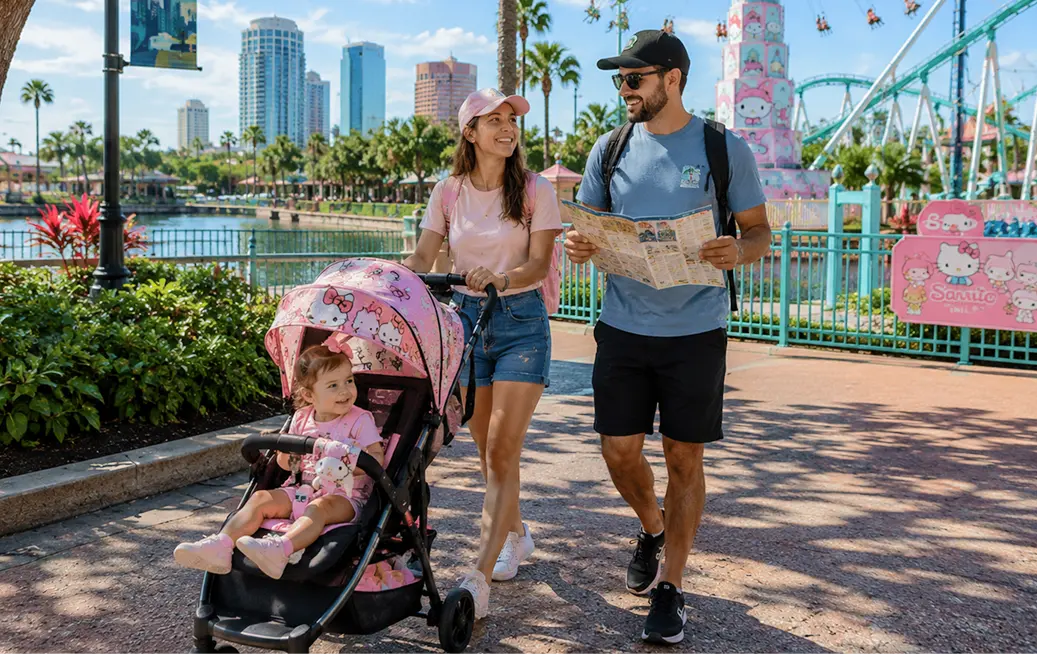 Young couple exploring Busch Gardens Tampa Bay with their toddler in a Hello Kitty-themed rental stroller from Cloud of Goods, father holding a park map with the Tampa skyline and Sanrio rides visible in the background.